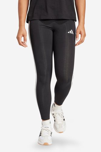 Modelka w legginsach sportowych, ujęcie sylwetki od pasa w dół z przodu.