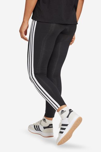 Modelka w legginsach sportowych, ujęcie sylwetki od pasa w dół z tyłu.