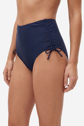 Modelka w majtkach bikini, ujęcie sylwetki z przodu do wysokości uda.