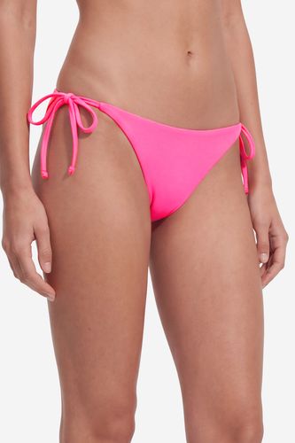 Modelka w majtkach od bikini, ujęcie sylwetki od góry do dołu.