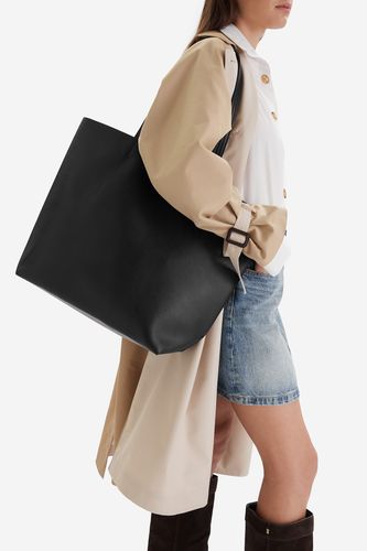 Modelka prezentująca dużą torebkę shopper na ramieniu.
