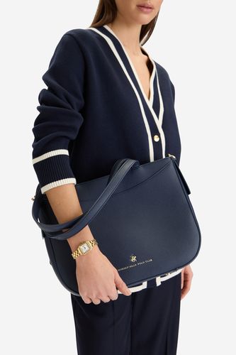 Modelka prezentująca torebkę przewieszoną przez ramię, widok na górną część sylwetki.