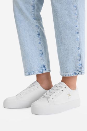 Modelka prezentująca buty na stopach, ujęcie nóg z dołu.
