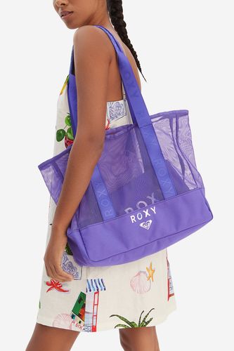 Modelka prezentująca torebkę shopper zawieszoną na ramieniu, ujęcie do połowy sylwetki.