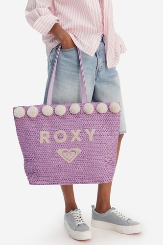 Modelka trzymająca torebkę shopperkę w dłoni, widok sylwetki od kolan w dół.