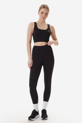 Modelka w legginsach sportowych, ujęcie całej sylwetki z przodu.