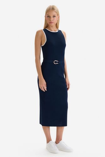 Modelka w sukience midi, widok na sylwetkę pod lekkim kątem.