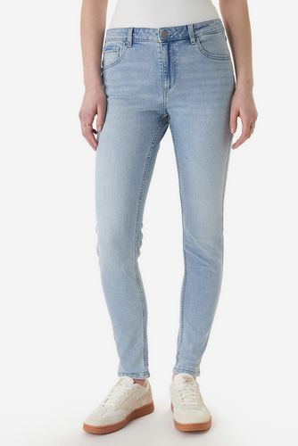Modelka w spodniach jeansowych, ujęcie całej sylwetki od przodu.