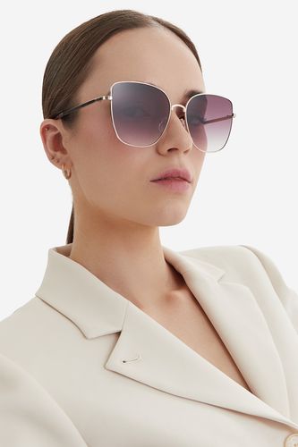 Modelka prezentująca okulary przeciwsłoneczne, ujęcie portretowe z przodu.