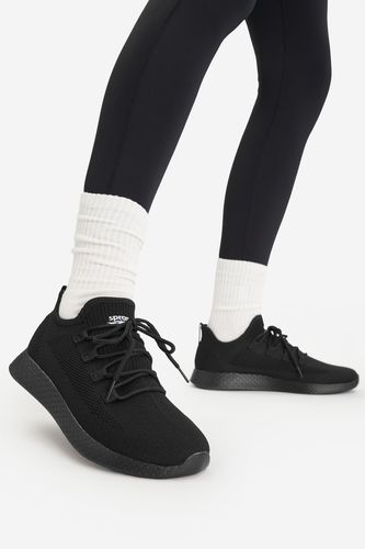 Model prezentujący buty na stopach, ujęcie nóg w ruchu.
