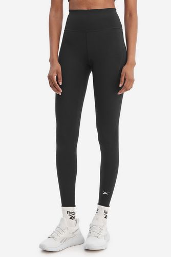Modelka stojąca przodem, prezentuje legginsy sportowe w pełnym ujęciu sylwetki.