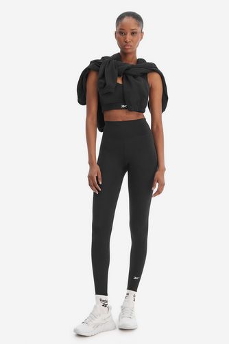 Modelka stojąca przodem, legginsy sportowe, bluza przewieszona przez ramiona.