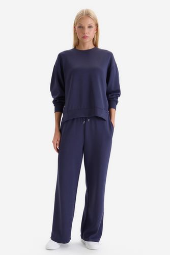 Modelka w komplecie dresowym, spodnie i bluza, ujęcie całej sylwetki z przodu.
