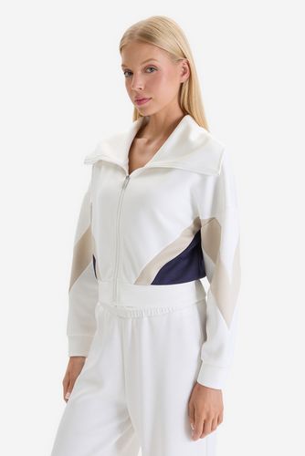 Modelka w rozpinanej bluzie, ujęcie sylwetki pod kątem z przodu.