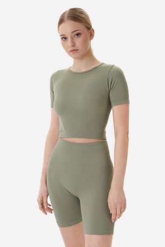 Modelka w komplecie sportowym, ujęcie sylwetki od góry do kolan.