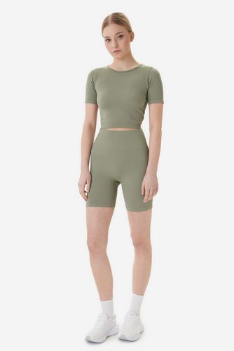 Modelka w komplecie sportowym, ujęcie całej sylwetki z przodu.