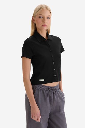 Modelka w koszulce z krótkim rękawem, ujęcie sylwetki do bioder z przodu.