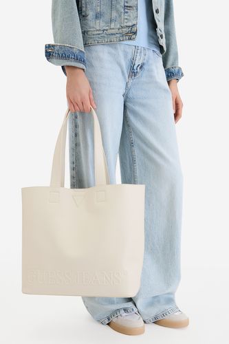 Modelka prezentująca shopperkę, torebka trzymana w dłoni, widok na sylwetkę.