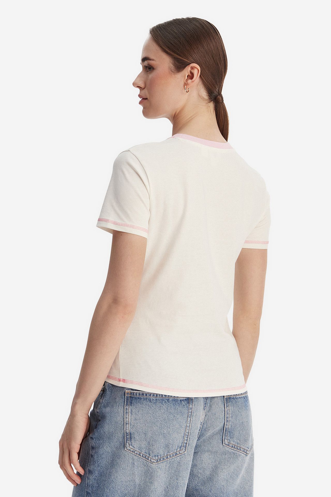 Modelka w T-shircie i dżinsach, widok na sylwetkę z tyłu.