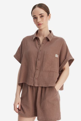 Modelka w koszuli z krótkim rękawem i szortach, ujęcie z przodu do uda.