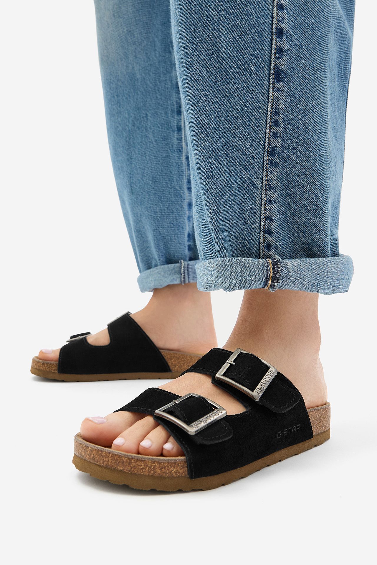 Stopy w sandałach, ujęcie od dołu na buty na modelu.
