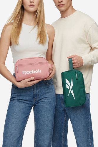 Modelka i model prezentują kosmetyczki trzymane w dłoniach przed sobą.
