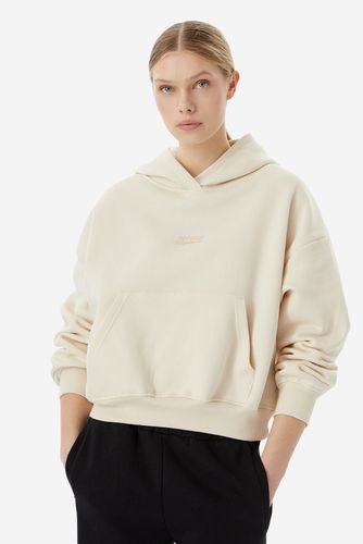 Modelka w bluzie z kapturem, ujęcie od przodu do połowy ud.