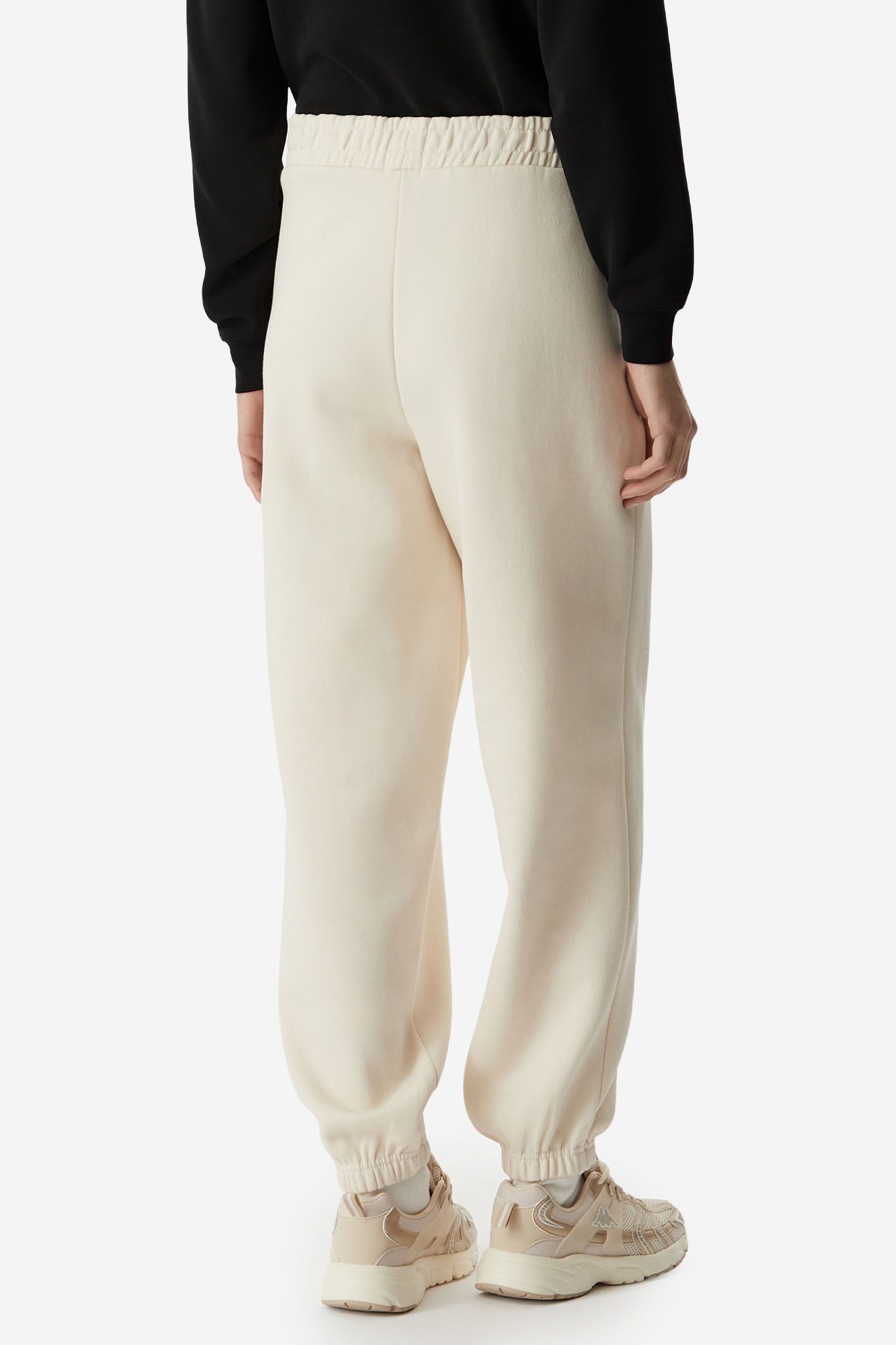 Modelka prezentująca spodnie, ujęcie sylwetki od pasa w dół z tyłu.