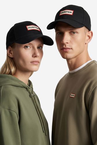 Modelka i model prezentujący czapki z daszkiem, widok z przodu.
