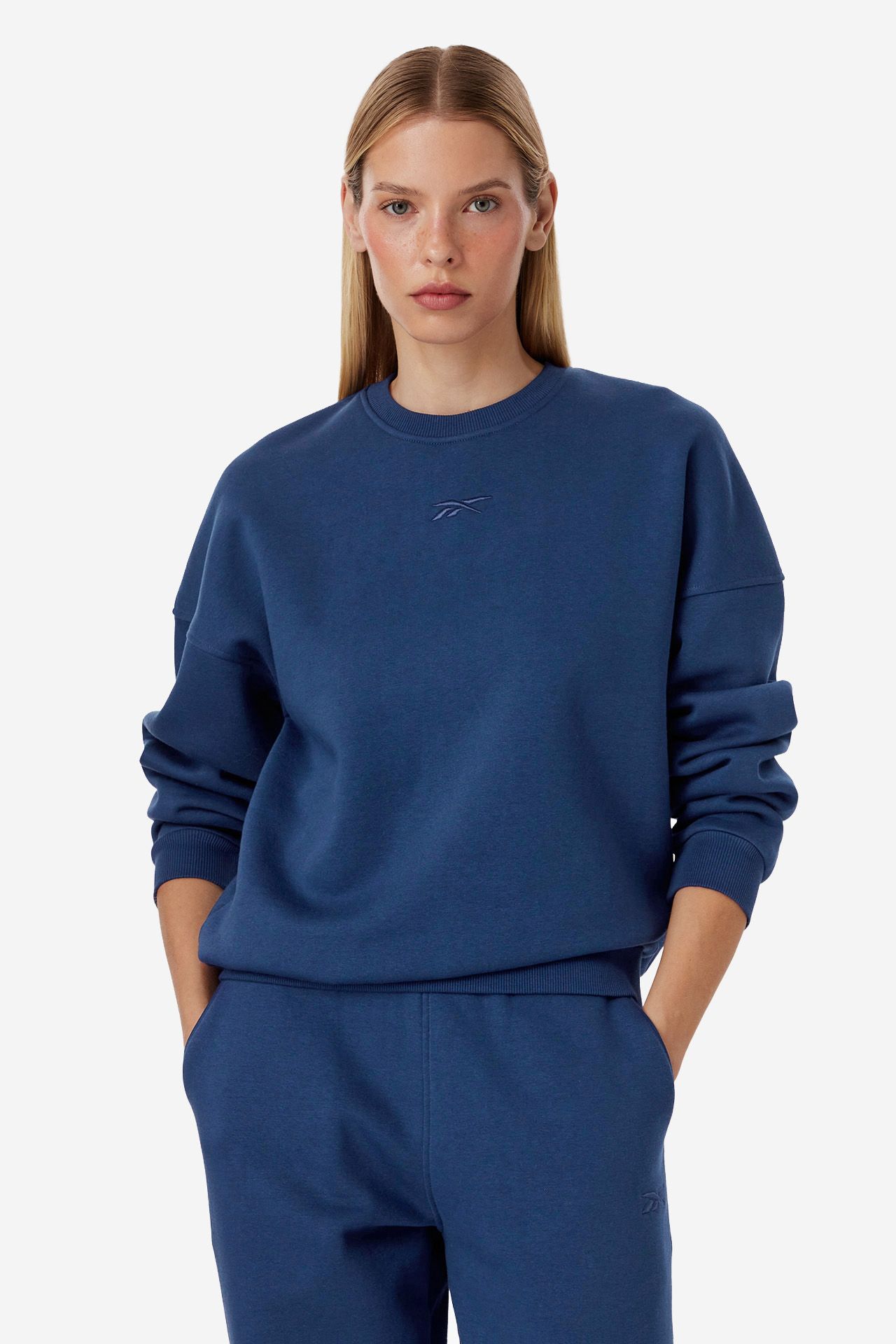 Modelka w dresowej bluzie, ujęcie z przodu od pasa w górę.